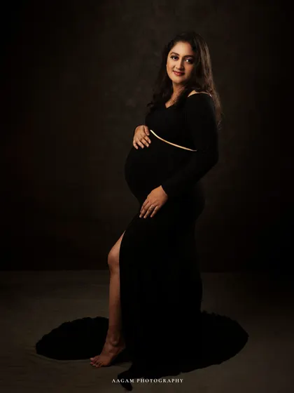 A full-length view shows the elegant silhouette of the black gown. The simplicity of the shot puts all the focus on her and her beautiful bump.