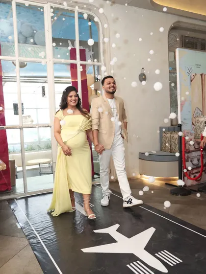 The parents-to-be making their grand entrance on a custom runway, with bubbles adding to the magic.