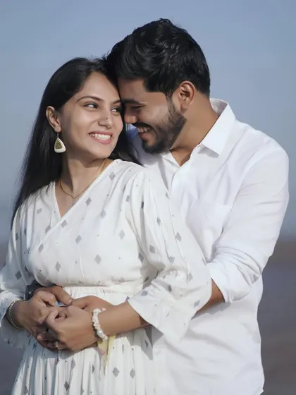 A happy, bright portrait on the beach. Their smiles are infectious, and the all-white outfits look beautiful against the blue sea.