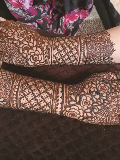 This design is all about florals, with intricate rose patterns covering the hands and arms. It's a very detailed and feminine style, ideal for making a statement at any event.