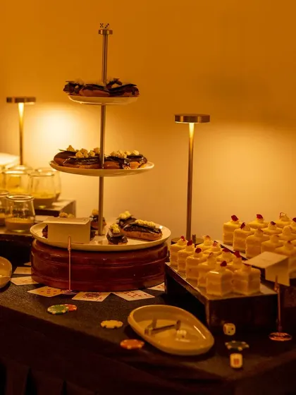 A dessert station from a Las Vegas-themed party, featuring tiered platters of various sweet treats.
