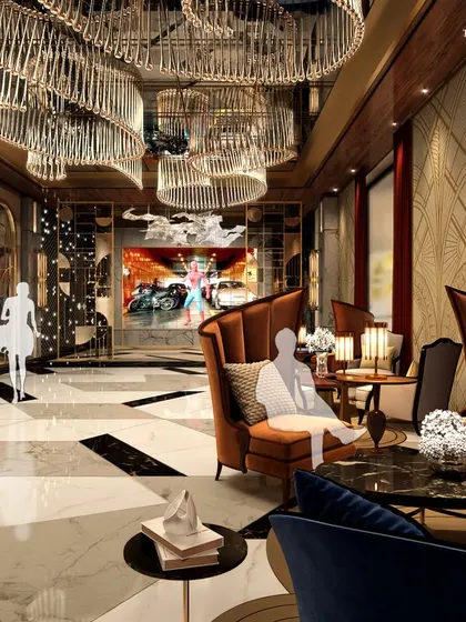 The lounge area of a luxury cinema, featuring plush high-back armchairs in rich jewel tones. The space is designed for comfort and sophistication, with dramatic chandeliers and marble accents creating an opulent pre-film experience.