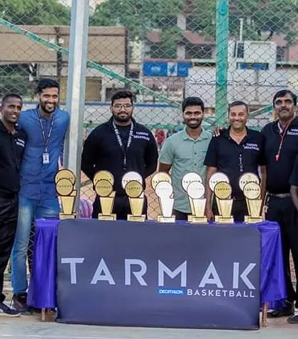A duplicate photo of the event organizers with the tournament trophies.
