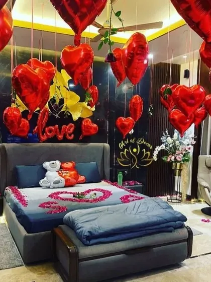 For a truly romantic gesture, I decorated this room with dozens of red heart-shaped foil balloons. The bed is adorned with artificial petals, and a 'love' sign adds to the intimate and special atmosphere.
