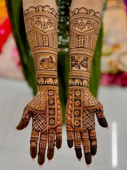 This symmetrical design features rows of elephants, auspicious wedding symbols like shehnai, and intricate floral grids on the palms.
