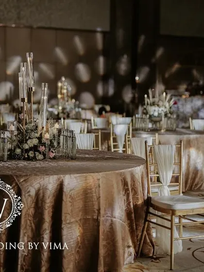 A classic and elegant reception setup symbolizing everlasting love. The stage features a modern, minimalist backdrop with custom monograms, floral arrangements, and soft lighting.