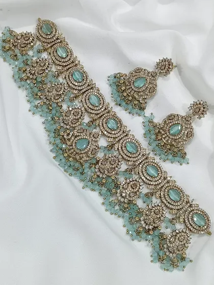 A choker set with a modern aesthetic, featuring pastel blue stones and jhumki-style earrings.