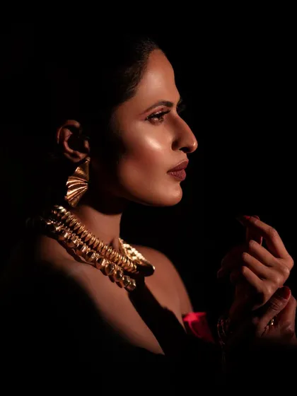A profile shot that uses dramatic side lighting to create a mysterious and captivating mood. This technique highlights the model's silhouette and the texture of her hair and makeup.