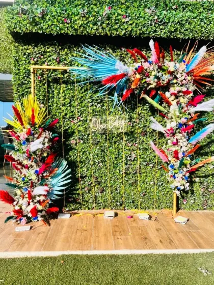 A vibrant and colorful floral backdrop with a neon sign, perfect for a lively and festive baby shower or birthday party.