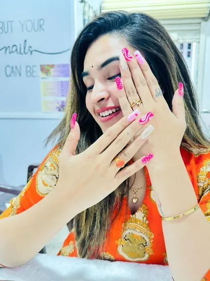 A happy client admiring her fun and colorful pink abstract nails. The smile says it all.