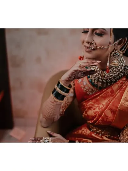 This portrait highlights the intricate details of the bride's jewelry and the rich color of her saree, capturing her elegance from a side profile.