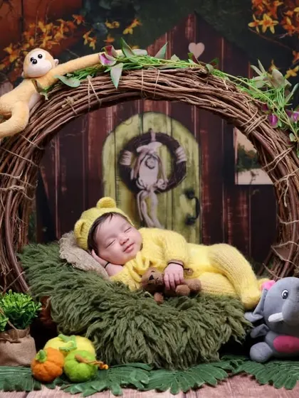A peaceful nap in the heart of the jungle. This shot shows the baby sleeping soundly amidst his plush animal friends in a cozy, nature-inspired setting.