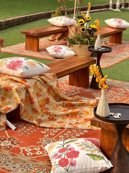 A cozy seating nook with printed rugs and cushions, creating a warm and inviting space for guests.