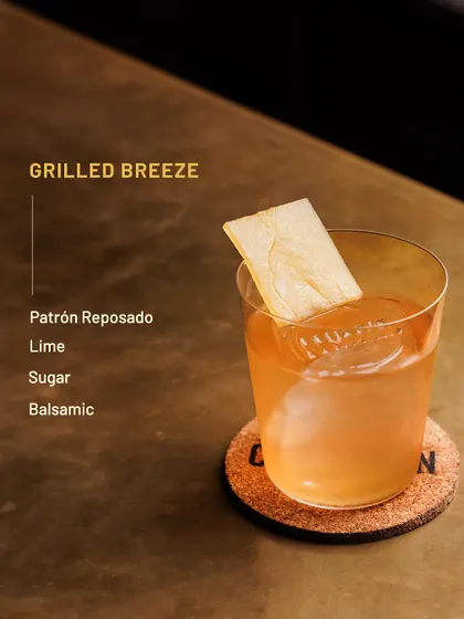 The Grilled Breeze, a smoky and tangy cocktail with Patrón Reposado and balsamic.
