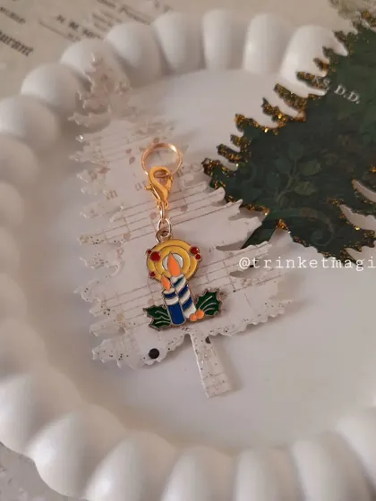 The Christmas candle charm, looking warm and bright against a festive background.