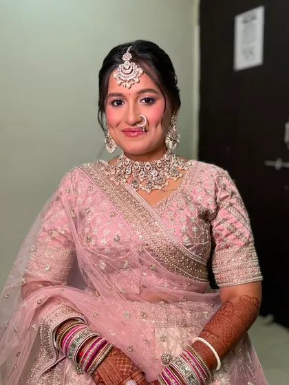 The final look is a picture of elegance. The soft pink tones in her makeup perfectly match her lehenga.