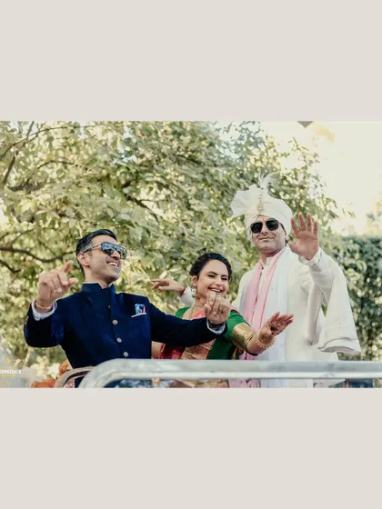 A fun and candid shot of the groom dancing in a car with his family during the Baraat.