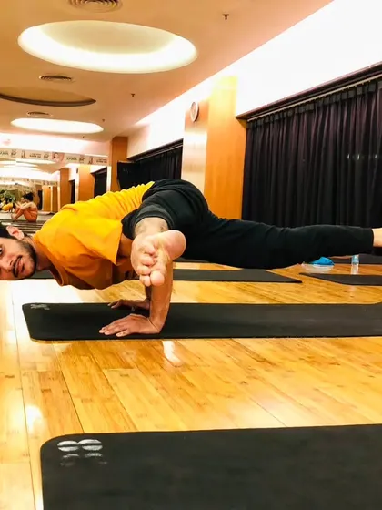 Koundinyasana II, a flying splits arm balance that demonstrates a high level of strength and flexibility.