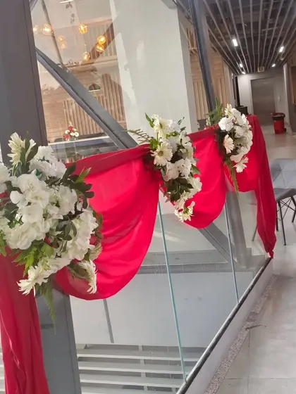 For the RedTape office, I also decorated the glass railings with red fabric and white floral bouquets. This small detail helps carry the event's color scheme through the entire space.