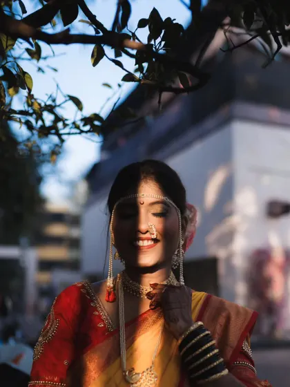 The play of light and shadow adds a beautiful, artistic touch to this bridal portrait. The bride's serene smile is captured perfectly as the sun peeks through the leaves.