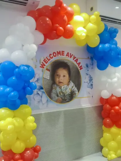 A colorful welcome arch with a personalized photo banner. The balloon arch uses primary colors for a bright and cheerful look.
