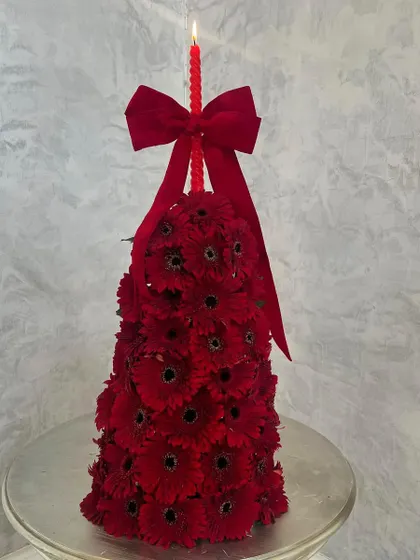 A chic and glorious Christmas tree made entirely of fresh red gerbera daisies. I topped it with a matching red candle and a velvet bow for a unique and festive holiday centerpiece.
