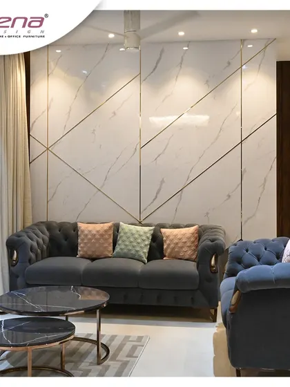 This living room features a classic Chesterfield sofa against a modern wall with geometric gold inlays on a marble-finish panel. It’s a great example of mixing classic and contemporary styles.