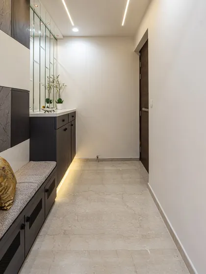 A view down the passage from the entryway. The clean lines, profile lighting, and neutral color palette create a calm and sophisticated transition into the rest of the home.