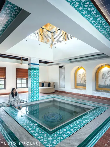 Inspired by the family's love for travel, we designed this serene, Moroccan-style indoor pool area for the Wanderlust Villa. The custom turquoise tiles, arched niches, and skylight work together to transport you to a tranquil riad, creating a personal oasis within the home.