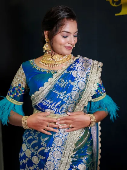 A close-up of the blue Banarasi drape, highlighting the intricate weaving and the way the fabric is pleated.