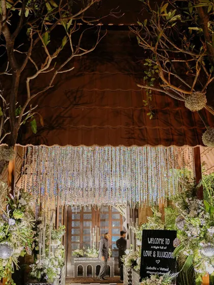 The entrance to the 'Love & Illusion' Sangeet, with a dramatic crystal curtain and enchanting tree branches.