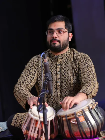 On stage, fully immersed in the performance. The intricate patterns on my kurta mirror the complex rhythms I create on the tabla, weaving a rich tapestry of sound.