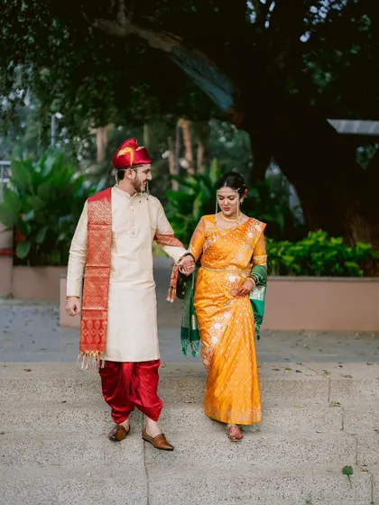 Mansi and Omkar walking down the steps together after their wedding ceremony.