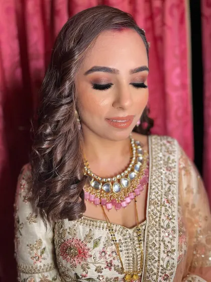 Akshita’s reception look was all about glam, gloss, and gorgeousness. I created a bronze smokey eye and a glossy nude lip to go with her ivory and pink lehenga.