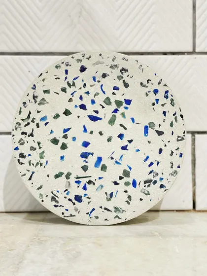 Tripping over terrazzo. This sample showcases a beautiful mix of blue, green, and white recycled chips, creating a vibrant and sustainable material for our custom furniture.
