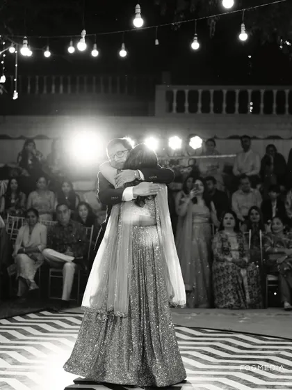 A beautiful black and white shot of a father-daughter dance, capturing the emotion of the moment under the spotlight.