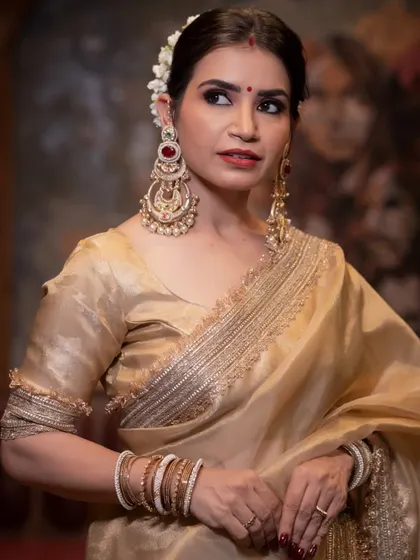 A close-up of the Rekha-inspired look, focusing on the classic winged liner, bold lip, and traditional jewellery.