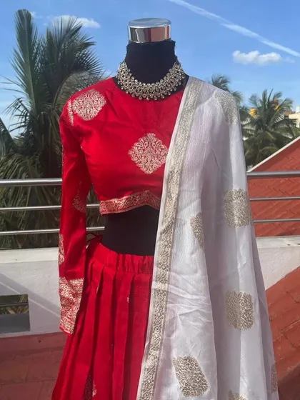 A classic red lehenga with a full-sleeve blouse and a contrasting white embroidered dupatta.