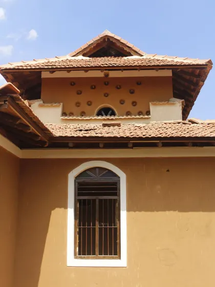 A detail of the exterior of the Doddaballapura mud house. The small, circular openings are made from inverted clay pots embedded in the wall, a traditional technique for creating ventilation and decorative patterns.