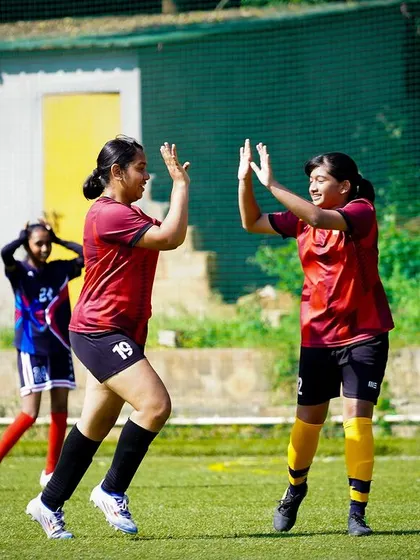 A high-five between teammates celebrates a good play, embodying the positive reinforcement and team spirit we encourage.