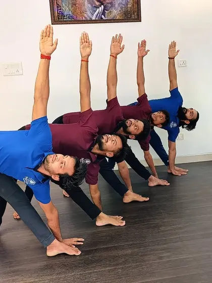 A line of students practicing Trikonasana (Triangle Pose), creating a beautiful geometric pattern with their bodies.