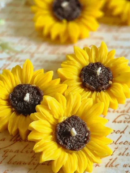 A close-up of the classic yellow sunflower floating candles. The details in the petals and center are crafted to look just like the real flower, bringing a bit of nature indoors.