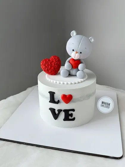 A simple and sweet cake for someone you love. This design features a cute grey teddy bear holding a red heart.