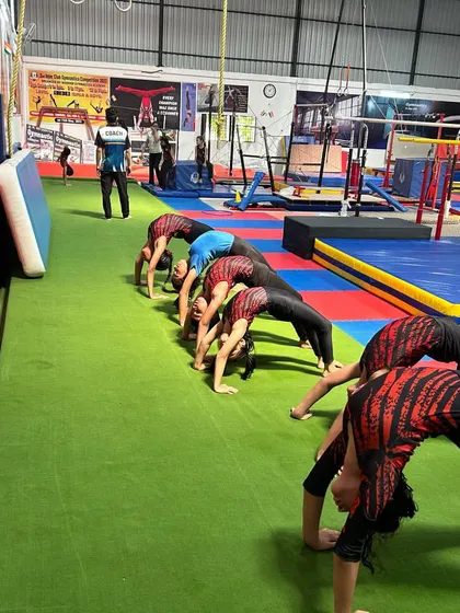 A line of gymnasts performing the bridge exercise. Repetition and correct form are key to developing the back flexibility needed for advanced tumbling and apparatus skills.