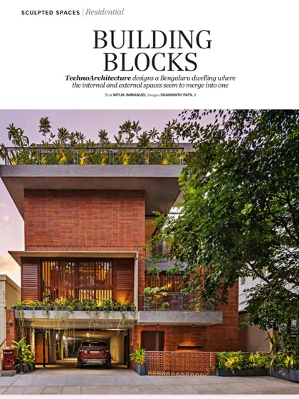 'The Far Site House' featured in a magazine, showcasing its 'Building Blocks' concept where the brick facade seems to merge with the landscape.