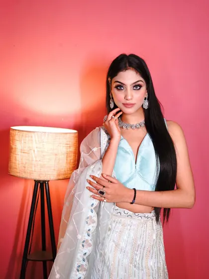 Another portrait in the white and blue lehenga, exuding quiet confidence.