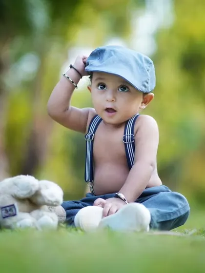 A dapper little gentleman tipping his cap. This charming outdoor portrait showcases how a simple prop can add so much personality to a photo.