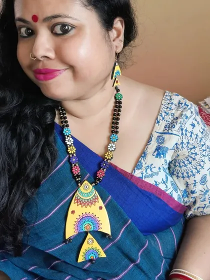 Here I am, wearing my hand-painted fish necklace. I love pairing my creations with my sarees to show how they can complete a look.