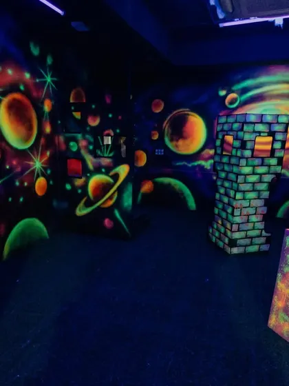 A glimpse of our multi-level laser tag arena, complete with cosmic murals and plenty of obstacles to make your game more strategic and exciting.