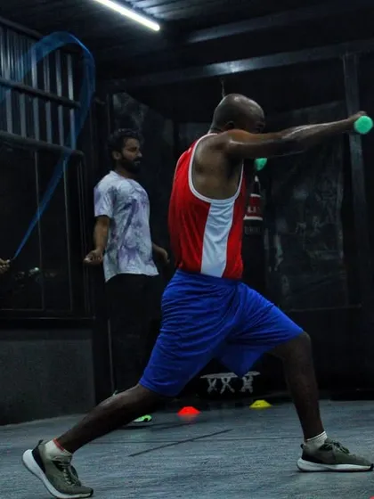 Building stamina and punching endurance. This fighter is working on his form with light weights while others skip rope to improve their footwork.